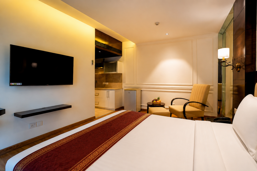 Studio room with bed and sitting area at Hotel GreySky South Delhi